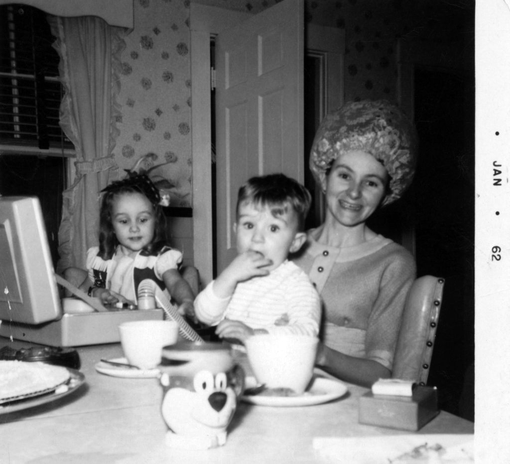 woman in wearing a hair dryer cap with two small children