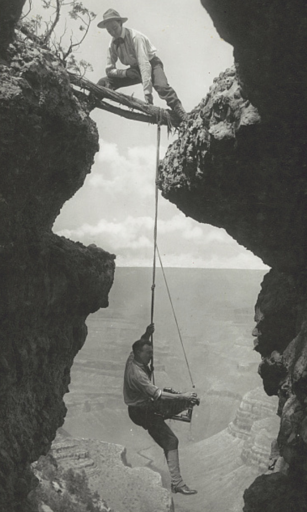 two men dangling over a crevasse in the grand canyon
