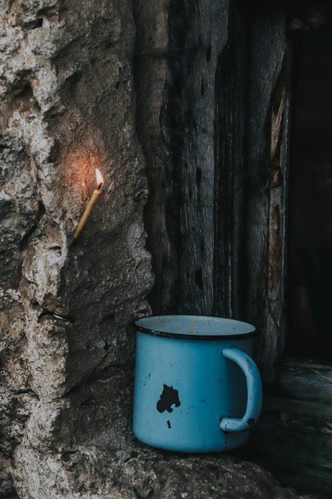 chipped blue enamel mug in a stone window